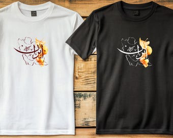 Può includere: Due magliette, una bianca e una nera, su una superficie di legno. Ognuna presenta un disegno con calligrafia ed elementi floreali nei toni dell'arancione e del marrone. Le magliette sono a maniche corte.