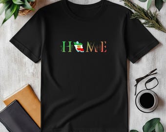 Può includere: T-shirt nera con la scritta "HOME" in verde, rosso e arancione. La "O" in "HOME" è una mappa di un paese con i colori di una bandiera. La maglietta è realizzata in un materiale morbido.