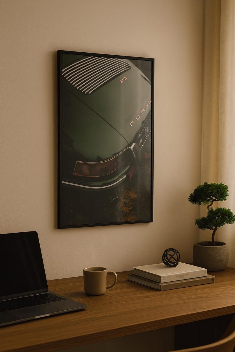 May include: Framed print of a vintage green Porsche car. The image shows the rear of the car with the word "Porsche" visible. The print is displayed on a wall above a wooden desk with a laptop, mug, and books.
