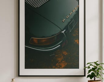 May include: Framed art print showing a close-up of a vintage dark green Porsche. The car's rear, with the word "Porsche" in gold lettering, is the focal point. The image has a vintage aesthetic, with a focus on the car's design and details.