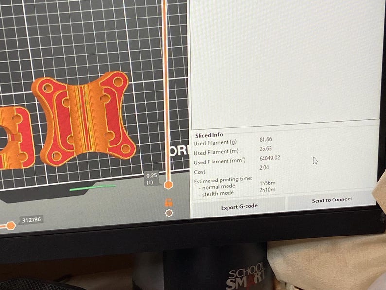 May include: A computer screen displays a 3D model of an orange and red object with a complex design. The screen also shows "Sliced Info" including filament usage and estimated printing time.