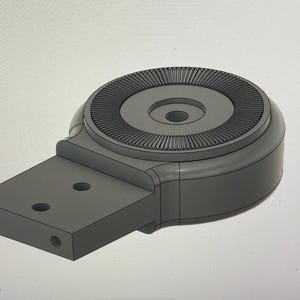 May include: A gray, 3D-rendered mechanical component with a circular top featuring a ridged design. It has a rectangular base with three holes and a rounded body. The object is likely a part of a larger machine or device.