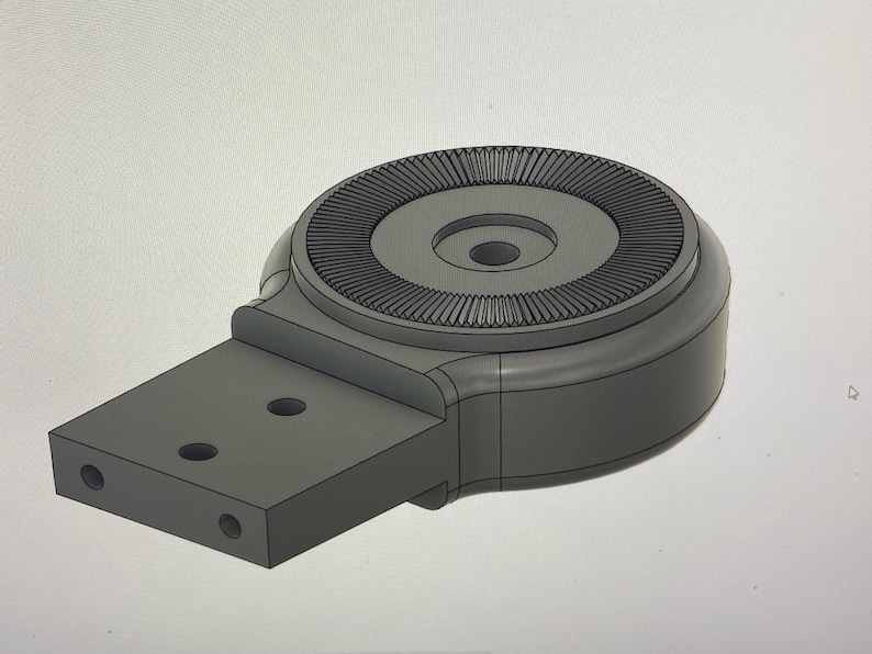 May include: A gray, 3D-rendered mechanical component with a circular top featuring a ridged design. It has a rectangular base with three holes and a rounded body. The object is likely a part of a larger machine or device.