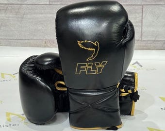 Guantes de entrenamiento y sparring Fly Boxing de piel de vacuno negra con logotipo dorado y cordones.