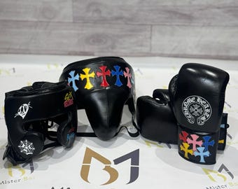 May include: Black leather boxing headgear and gloves set. The headgear features a row of colorful cross patches and white graphic prints including a spiderweb and the text Sex Records. The gloves display a Chrome Hearts logo and colorful crosses.