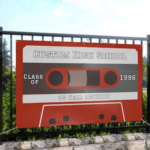 May include: A rectangular banner featuring a red and grey cassette tape graphic. The text reads CUSTOM HIGH SCHOOL, CLASS OF 1996, and 30 YEAR REUNION. The banner has metal grommets along the top edge for hanging and is displayed on a black metal fence.