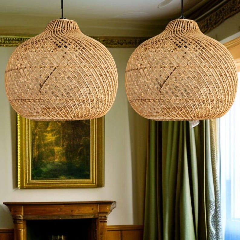 May include: Two spherical pendant lights made from woven rattan hang from the ceiling. The light fittings have a woven pattern. The lights are suspended by black cords. The background includes a painting and green curtains.