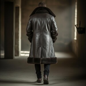 May include: A long, dark brown leather coat with a shearling collar and trim. The coat is knee-length and has a classic design. The person is wearing black pants and brown boots. The coat is a stylish outerwear garment.