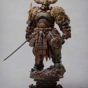 May include: A detailed statue of an Oni Colossus warrior, featuring intricate armor in shades of teal, gold, and purple. The figure holds a katana and stands on a base adorned with skulls. The statue is 1/6 scale.