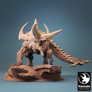 Op de afbeelding: Een gedetailleerd, beige miniatuur drakenbeeldje met grote hoorns, scherpe tanden en een lange, geschubde staart. De draak poseert op een stenen structuur, met ingewikkelde details. Het Rescale Miniatures logo staat rechtsonder.