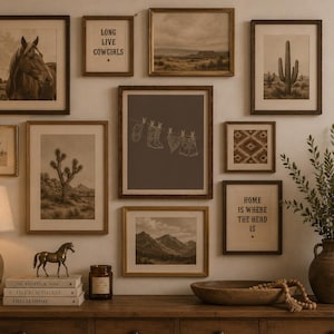 May include: A gallery wall featuring framed art prints with a rustic, western theme. The prints depict a horse, desert landscapes, cacti, and the text "LONG LIVE COWGIRLS" and "HOME IS WHERE THE HERD IS". A lamp, books, and decorative items sit on a wooden surface.
