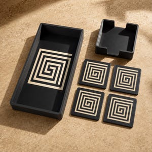 May include: A black rectangular tray and four square coasters with a matching cream-colored geometric spiral pattern. The set includes a black open-top holder for the coasters, which are arranged in a stackable configuration next to the tray.