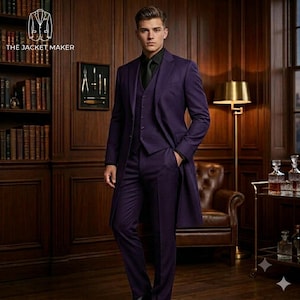 May include: A deep purple three-piece suit consisting of a long coat, a waistcoat, and trousers, worn with a black shirt and black tie. The logo for THE JACKET MAKER is visible in the upper left corner above a framed display of metal tools.