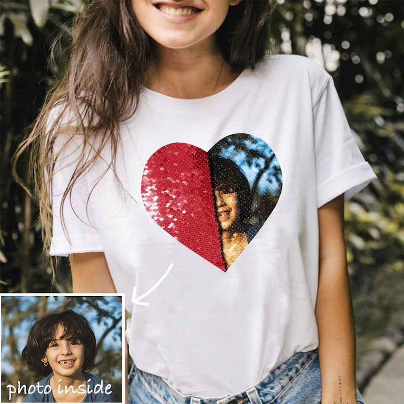 Puede incluir: Camiseta blanca con dise&ntilde;o de coraz&oacute;n. La mitad del coraz&oacute;n es de lentejuelas rojas y la otra mitad es una foto de una persona. Las palabras "photo inside" est&aacute;n en un recuadro en la esquina inferior izquierda.