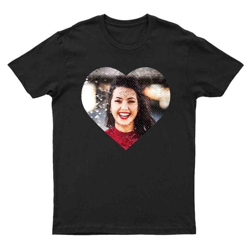 Puede incluir: Camiseta negra con un dise&ntilde;o en forma de coraz&oacute;n. El dise&ntilde;o presenta una fotograf&iacute;a de una persona sonriente que lleva una camiseta roja. La imagen est&aacute; centrada en la parte delantera de la camiseta.