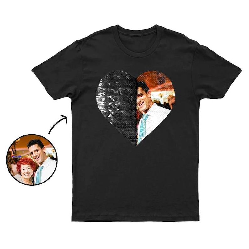 Puede incluir: Camiseta negra con un dise&ntilde;o en forma de coraz&oacute;n. Una mitad del coraz&oacute;n est&aacute; cubierta de lentejuelas negras, la otra mitad muestra una fotograf&iacute;a de un hombre. Una peque&ntilde;a imagen circular del hombre y una mujer est&aacute; en la esquina inferior izquierda.