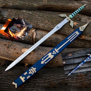 May include: A silver sword with a blade and a hilt featuring gold accents and a turquoise grip. The sword rests on a bed of wooden logs, accompanied by a blue sheath with gold designs. A smaller sheath is also visible.