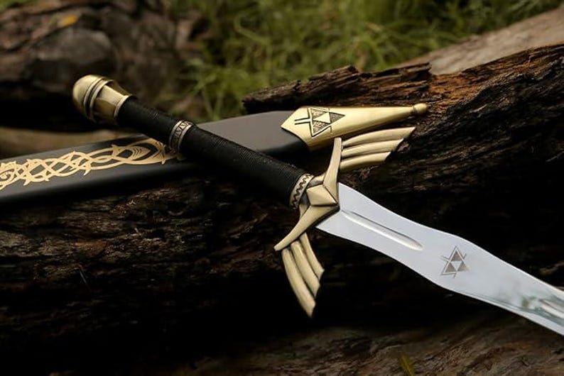 May include: A decorative sword with a silver blade and gold accents. The hilt is black with gold detailing, and the scabbard is black with gold Celtic knotwork. The sword is resting on a piece of wood.