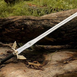 May include: A silver sword with a double-edged blade, featuring a black and gold handle. The sword has a decorative hilt with gold accents and a triangular emblem on the blade. The sword is resting on a weathered log.