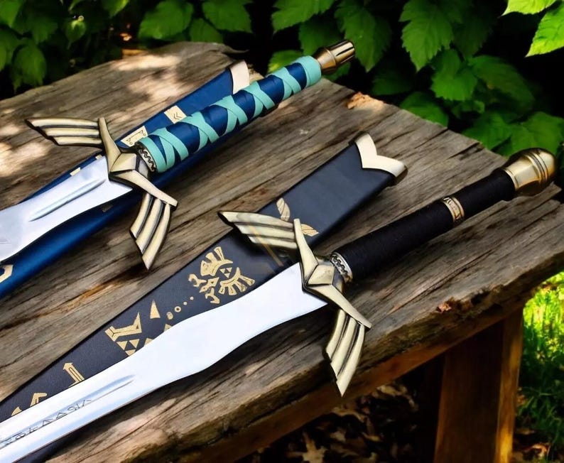 May include: Three decorative swords with gold detailing and sheaths. The swords have silver blades and black handles. One sword has a blue sheath, another a black sheath with gold designs, and the third a blue and teal handle.