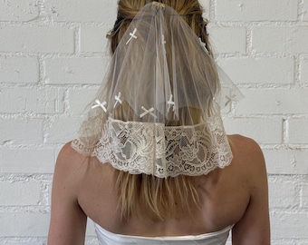 Velo de novia corto de encaje estilo vintage con pañuelo y lazos.