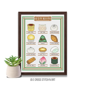 May include: A framed cross-stitch artwork featuring various dim sum dishes, including siu mai, har gow, and spring rolls. The artwork is in a brown frame and includes the text "DIM SUM" at the top. A small potted plant sits in front of the artwork.