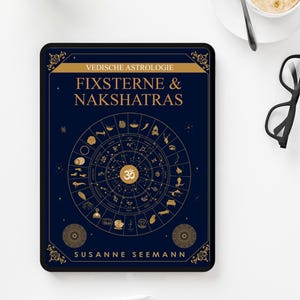 Peut inclure: Une tablette affiche une couverture de livre avec le titre "FIXSTERNE & NAKSHATRAS" en lettres dorées sur fond bleu foncé. La couverture présente un cercle astrologique avec des symboles et le nom de l'auteur, Susanne Seemann.