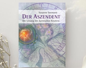 Puede incluir: Portada de libro con el título "DER ASZENDENT" en letras moradas grandes. La portada presenta un diseño de acuarela con un dragón, flores y símbolos astrológicos. También es visible el nombre del autor, Susanne Seemann.
