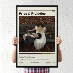 May include: A framed poster for the film "Pride & Prejudice" with the title and credits. The image shows a couple on a park bench, with the man in a suit lying down and the woman in a white dress sitting. The film's release year, 2005, is also visible.