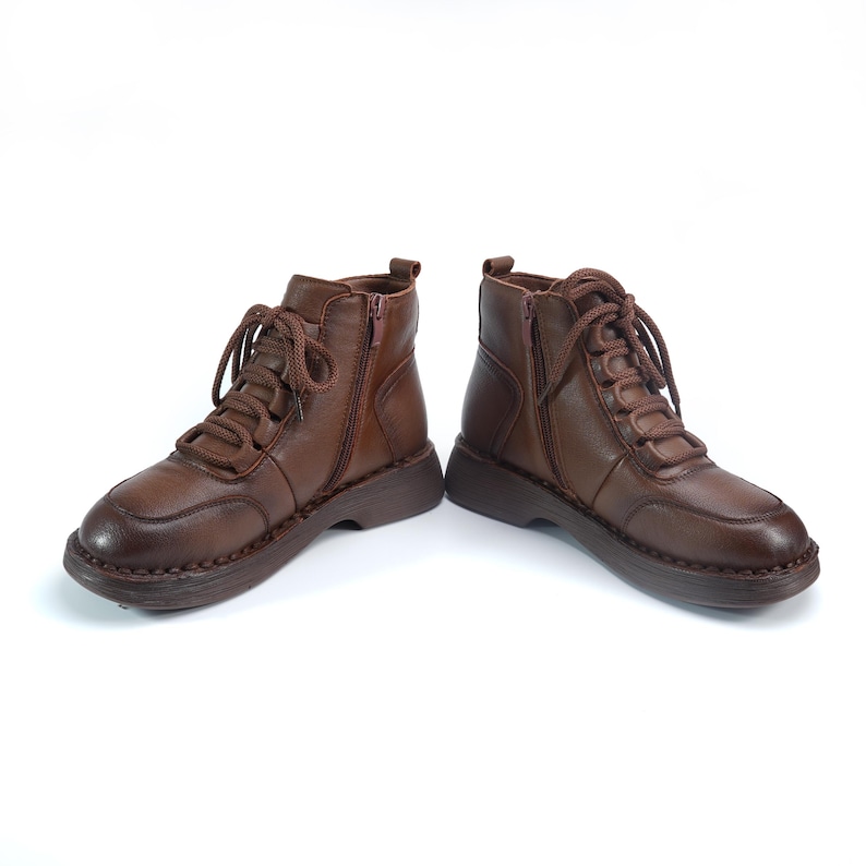 Puede incluir: Un par de botines de cuero marr&oacute;n con cordones y cremalleras laterales. Los botines tienen una puntera redondeada y una suela gruesa. El cuero tiene un aspecto ligeramente desgastado. Los botines est&aacute;n dise&ntilde;ados para el uso diario.