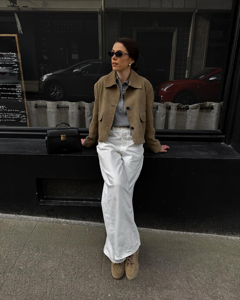 Woman in structured beige leather jacket with neutral tones and timeless capsule wardrobe look