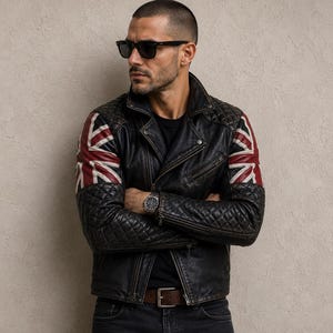 May include: A black leather motorcycle jacket featuring quilted detailing on the sleeves and shoulders, accented with a red, white, and blue Union Jack flag pattern on the upper arms. The jacket includes a notched collar, metal zippers, and a belt.