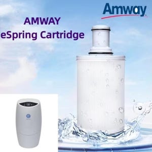 Puede incluir: Cartucho de filtro de agua eSpring blanco con diseño cilíndrico. La imagen muestra el cartucho con agua salpicando alrededor, y el logotipo de Amway es visible en la esquina superior derecha. También se muestra el texto "AMWAY eSpring Cartridge".