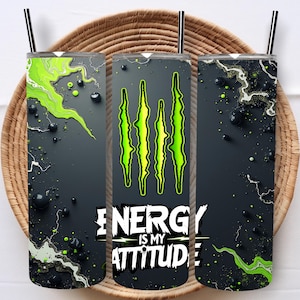May include: Three stainless steel tumblers with black straws, featuring a dark gray background with green and black accents. The tumblers have the Monster Energy logo and the text "ENERGY IS MY ATTITUDE."