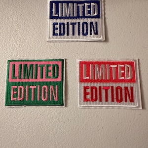 May include: Three embroidered patches with the words "LIMITED EDITION". One patch has a blue border and white background, another has a green border and pink text, and the last has a red border and white background.