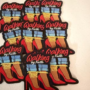 May include: A collection of embroidered patches featuring the text Walking by Faith in red script. Each patch depicts a pair of legs wearing blue cuffed jeans and red high-heeled shoes, with a gold chain around the ankle that reads FAITH.