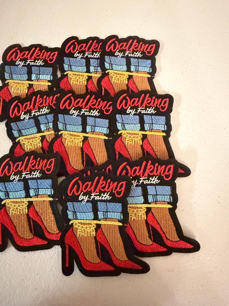 May include: A collection of embroidered patches featuring the text Walking by Faith in red script. Each patch depicts a pair of legs wearing blue cuffed jeans and red high-heeled shoes, with a gold chain around the ankle that reads FAITH.