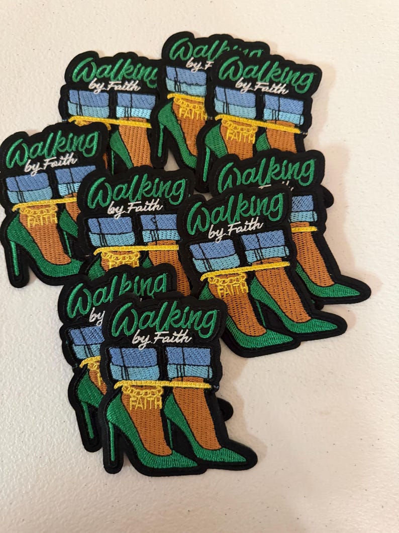 May include: A collection of embroidered patches featuring a pair of green high-heeled shoes, blue cuffed jeans, and a gold chain anklet with the word FAITH. The text Walking by Faith is embroidered in green script above the shoes.