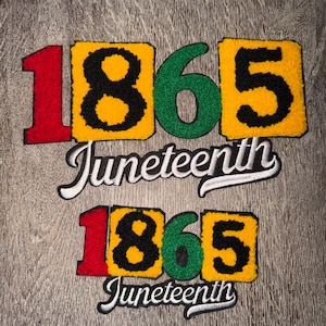 May include: Two Juneteenth patches with the numbers "1865" in red, black, and green, with a yellow border. The word "Juneteenth" is written in a cursive font below the numbers. The patches are on a wood-grain background.