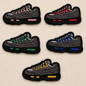May include: Five embroidered sneaker patches featuring a dark grey base with layered wave detailing. Each patch displays a unique accent color on the eyelets and sole units, including pink, red, green, blue, and yellow thread embroidery.