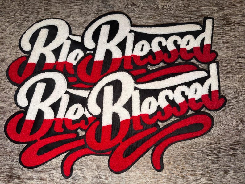 Puede incluir: Parches bordados con el texto "Rio Blessed" en una escritura estilizada. Los parches presentan una combinaci&oacute;n de colores blanco, rojo y negro, con un aspecto texturizado y en relieve. Los parches son probablemente para ropa o accesorios.