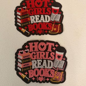 May include: Two embroidered patches featuring the text HOT GIRLS READ BOOKS. One patch uses red and white thread, the other uses pink and white. Both depict a stack of books labeled Romance, Fantasy, Mystery, Classics, a coffee cup, a lipstick, and a purse.