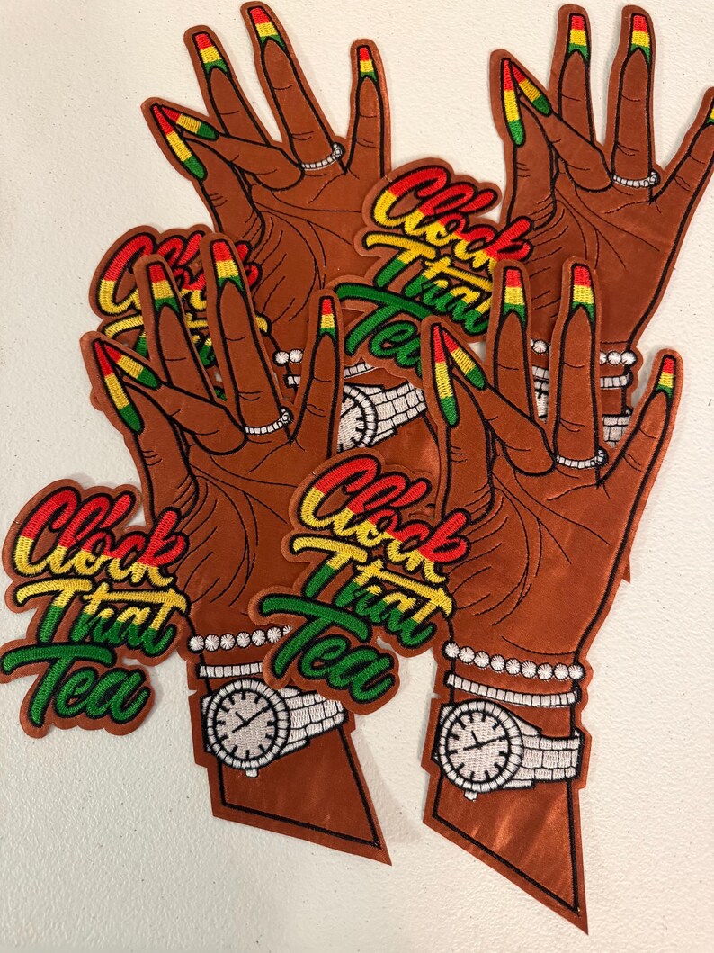 K&ouml;nnte beinhalten: Mehrere gestickte Aufn&auml;her, die eine braune Hand mit langen, in Rot, Gelb und Gr&uuml;n lackierten N&auml;geln zeigen. Die Hand tr&auml;gt einen Ring und eine Uhr, wobei der Text "Clock That Tea" in rotem, gelbem und gr&uuml;nem Garn gestickt ist.