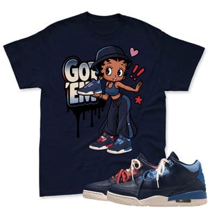 May include: A navy blue t-shirt featuring a cartoon character wearing a bucket hat, crop top, and sweatpants, holding a blue and white sneaker. The text "GOT 'EM" appears in a graffiti style. A pair of matching navy blue and white sneakers is shown.