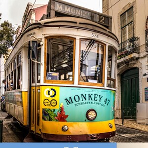 Puede incluir: Un tranv&iacute;a amarillo y blanco vintage con el texto "MONKEY 47 SCHWARZWALD DRY GIN" en la parte delantera. El tranv&iacute;a est&aacute; en un entorno urbano con edificios y calles empedradas. El texto "Lisboa de bolso para crian&ccedil;as" est&aacute; en la parte superior.