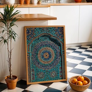 May include: A framed, intricately carved wooden panel with a teal and gold mandala design. The panel is leaning against a white wall, next to a potted plant and a basket of oranges. The frame is made of light-coloured wood.