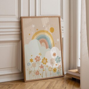 Può includere: Una stampa artistica da parete verticale incorniciata con sfondo beige che raffigura un arcobaleno multicolore sopra nuvole bianche. Il design include un sole giallo, piccole stelle e un campo di fiori vari in tonalità gialle, blu e rosa.