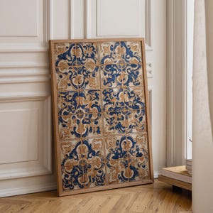May include: A rectangular wooden frame containing a grid of twelve ceramic tiles. Each tile features a repeating pattern of intricate, swirling dark blue and muted gold floral motifs set against a cream-coloured background, arranged in a four-by-three layout.