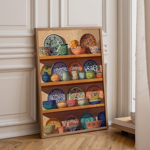 May include: A framed art print featuring a collection of colorful ceramic plates and bowls arranged on four wooden shelves. The illustration displays various patterns, floral motifs, and solid colors including blue, orange, green, and yellow.