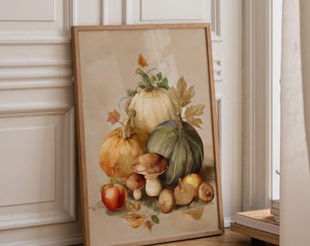 May include: A framed wall art print featuring a watercolor illustration of autumn harvest elements. The composition includes a large cream pumpkin, a dark green pumpkin, an orange pumpkin, red apples, and various brown mushrooms with fallen leaves.
